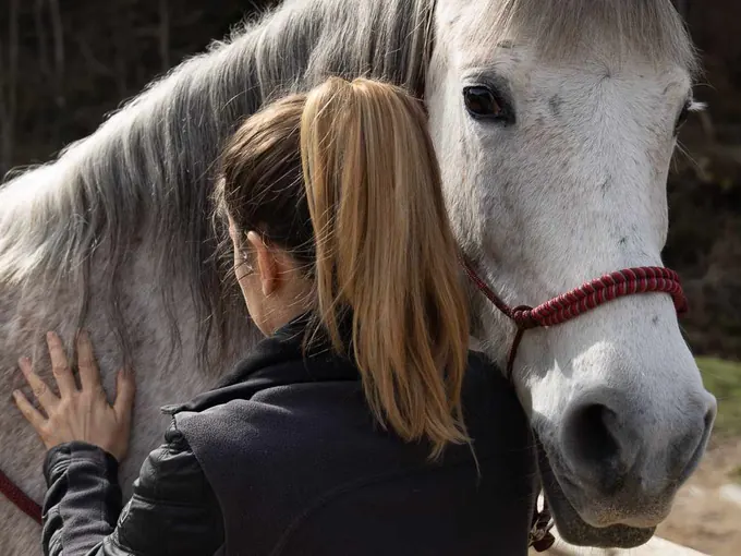 Séance près de l'encolure d'un cheval blanc