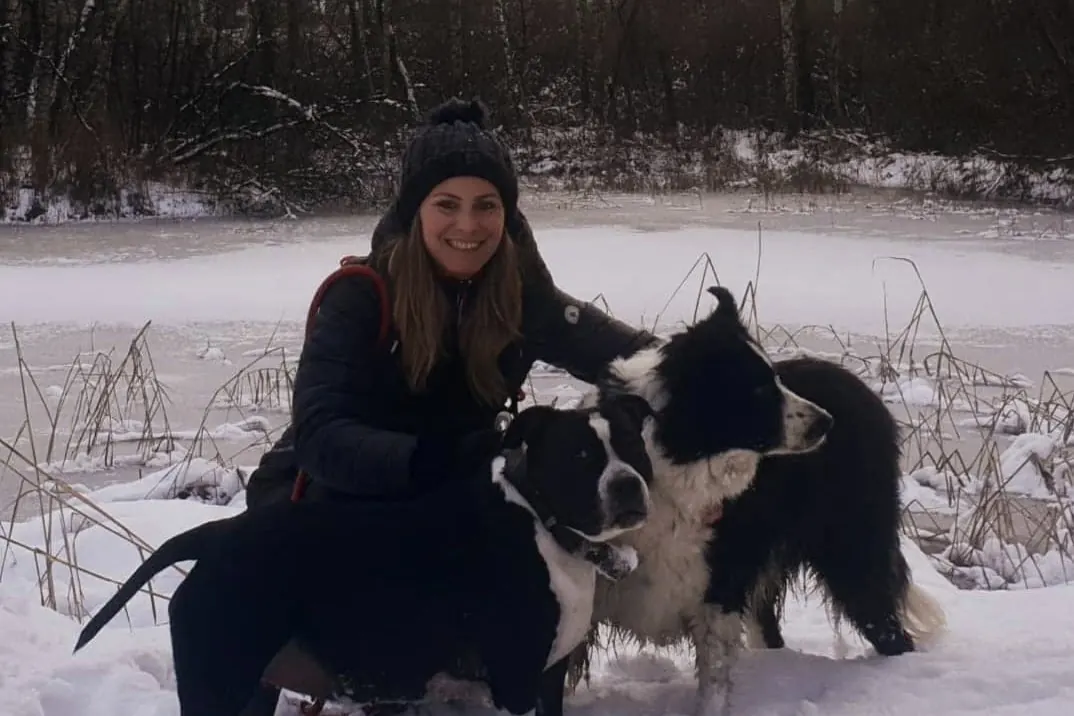 Lydie Autrand accroupie dans la neige avec ses deux chiens